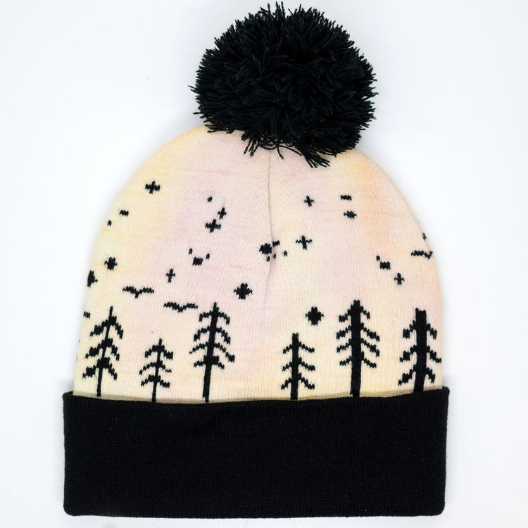 Cream and peach hand-dyed kids winter beanie with black pom-pom, folded cuff and moonlit forest pattern.
