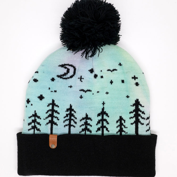 Hand-dyed kids winter beanie fading from lavender to light blue with black pom-pom and forest design.
