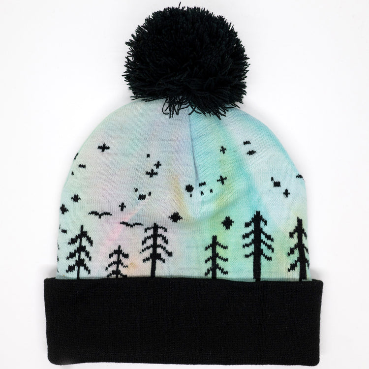Hand-dyed kids winter beanie fading from lavender to light blue with black pom-pom and forest design.
