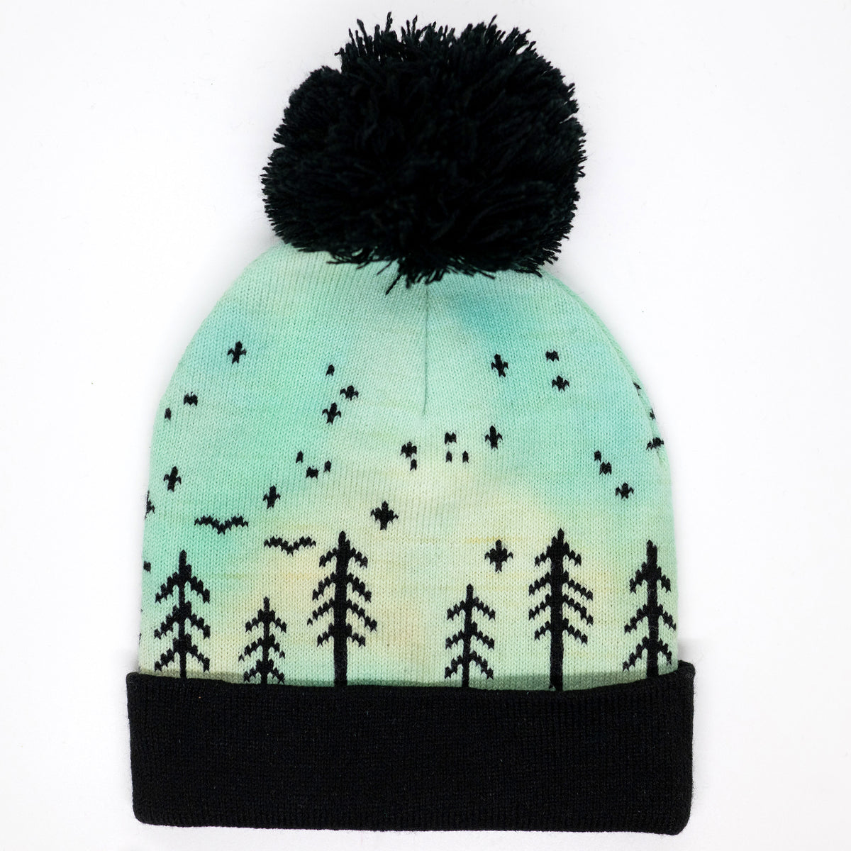 Hand-dyed kids winter beanie fading from yellow to light blue-green with black pom-pom and forest design.