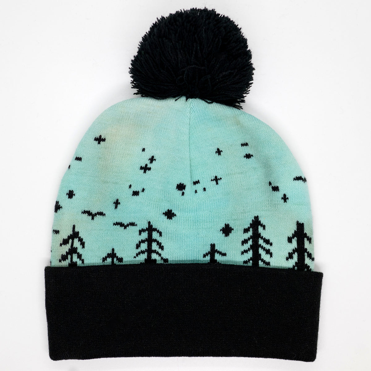 Hand-dyed kids winter beanie fading from lavender to light blue with black pom-pom and forest design.