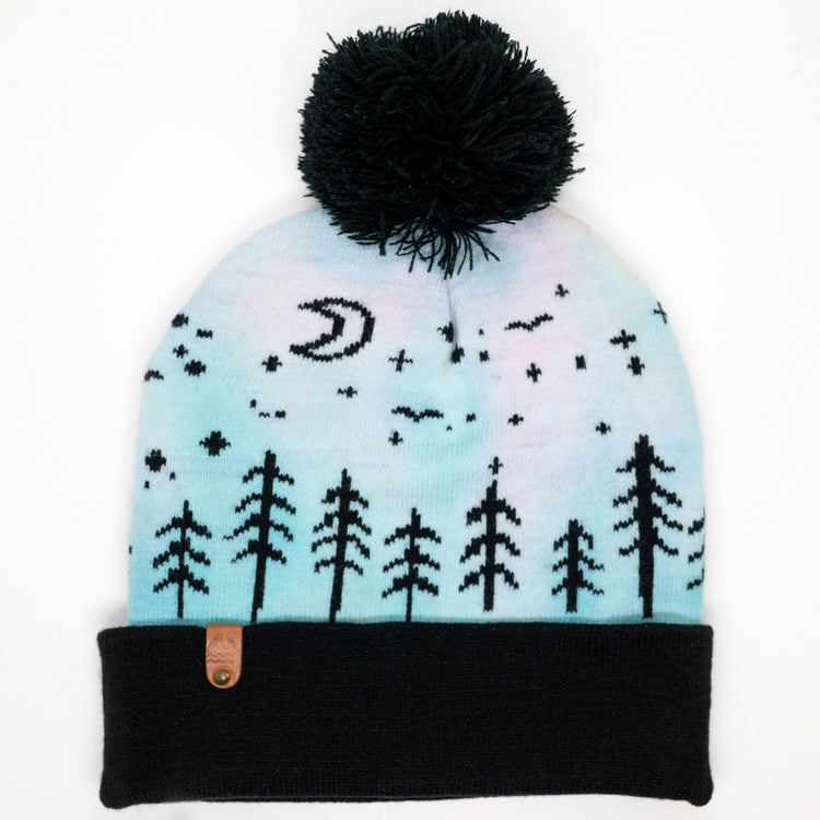 Hand-dyed kids winter beanie fading from lavender to light blue with black pom-pom and forest design.