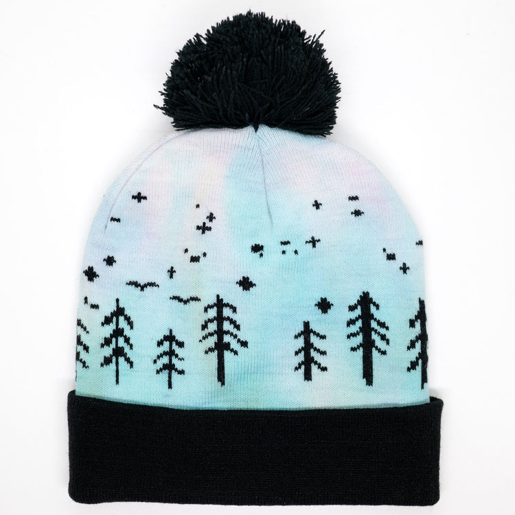 Hand-dyed kids winter beanie fading from lavender to light blue with black pom-pom and forest design.