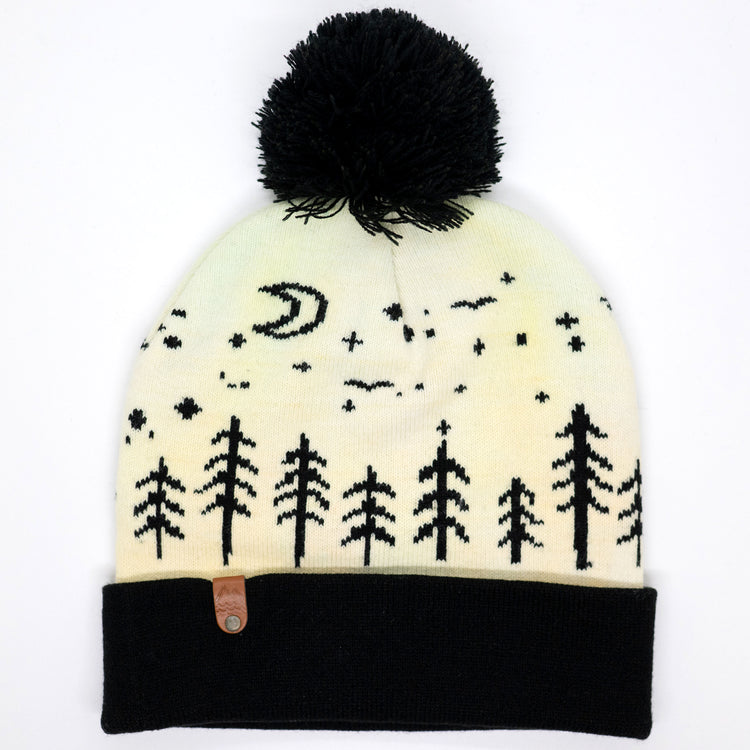 Hand-dyed kids winter beanie fading from yellow to peach with black pom-pom and forest design.