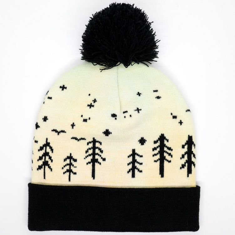 Hand-dyed kids winter beanie fading from yellow to peach with black pom-pom and forest design.