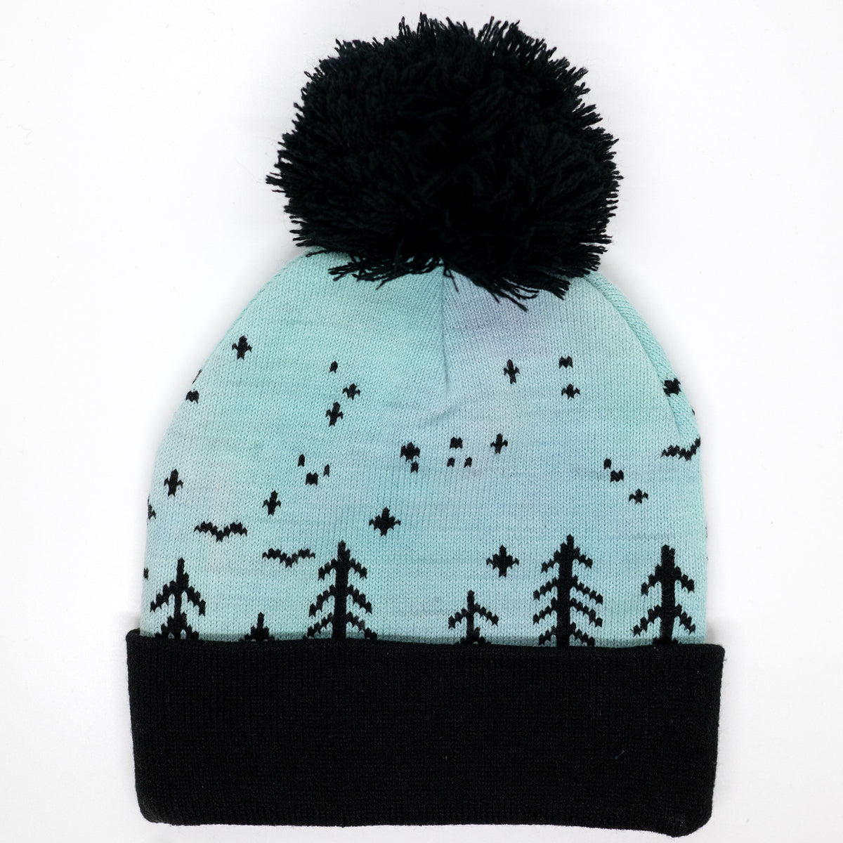Hand-dyed kids winter beanie fading from blue to green and purple with black pom-pom and forest design.