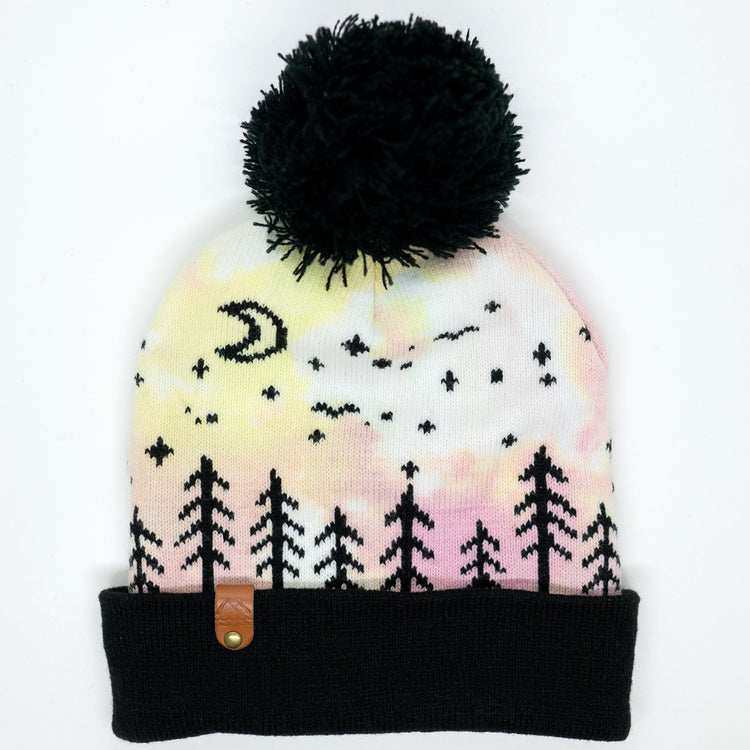 Hand-dyed pink, and yellow kids winter beanie with black pom-pom, folded cuff, pine trees, moon and stars.