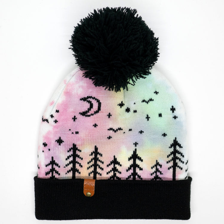 Hand-dyed pink, yellow, blue, and purple kids winter beanie with black pom-pom, folded cuff, pine trees, moon and stars.