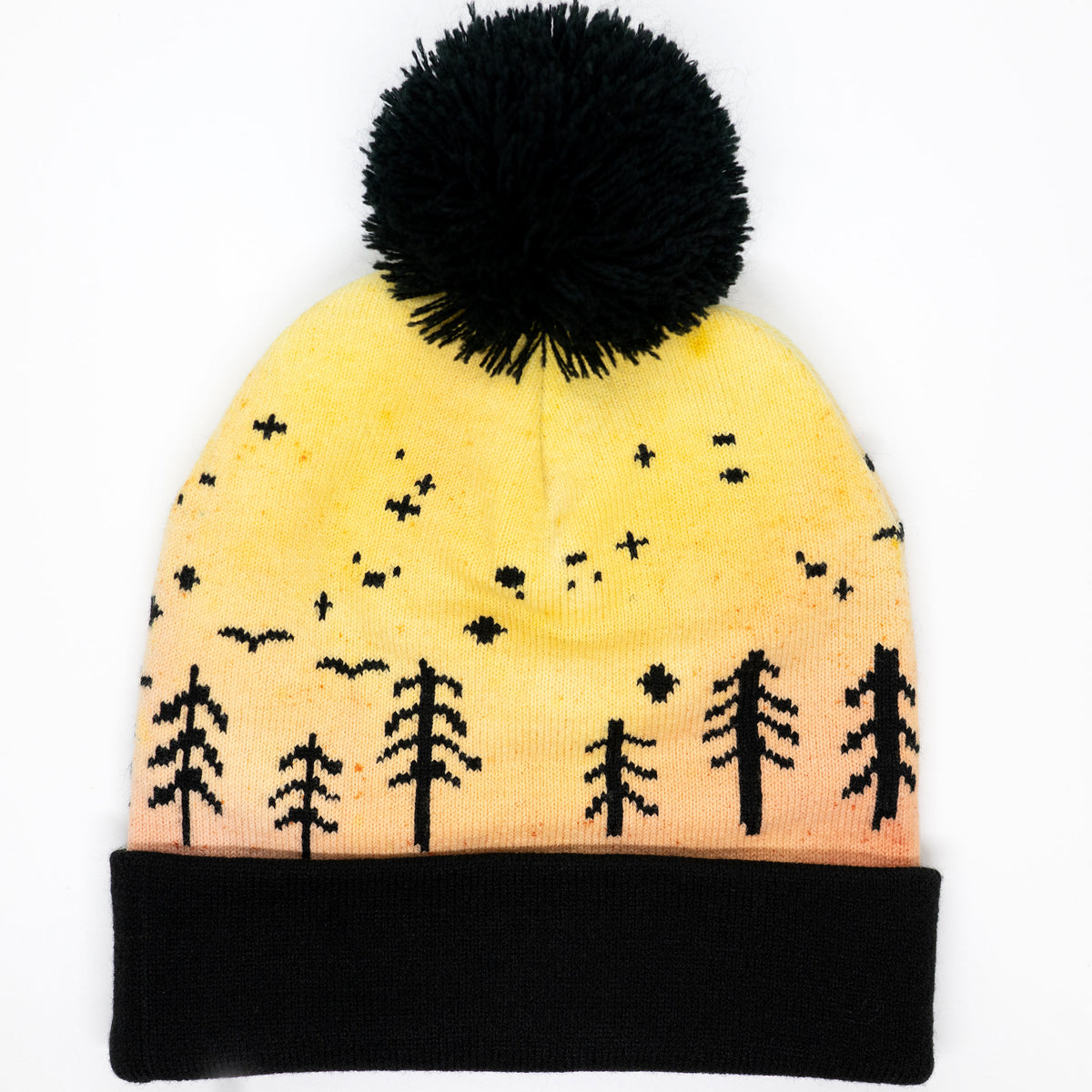 Hand-dyed kids winter beanie fading from yellow to orange with black pom-pom and forest design.