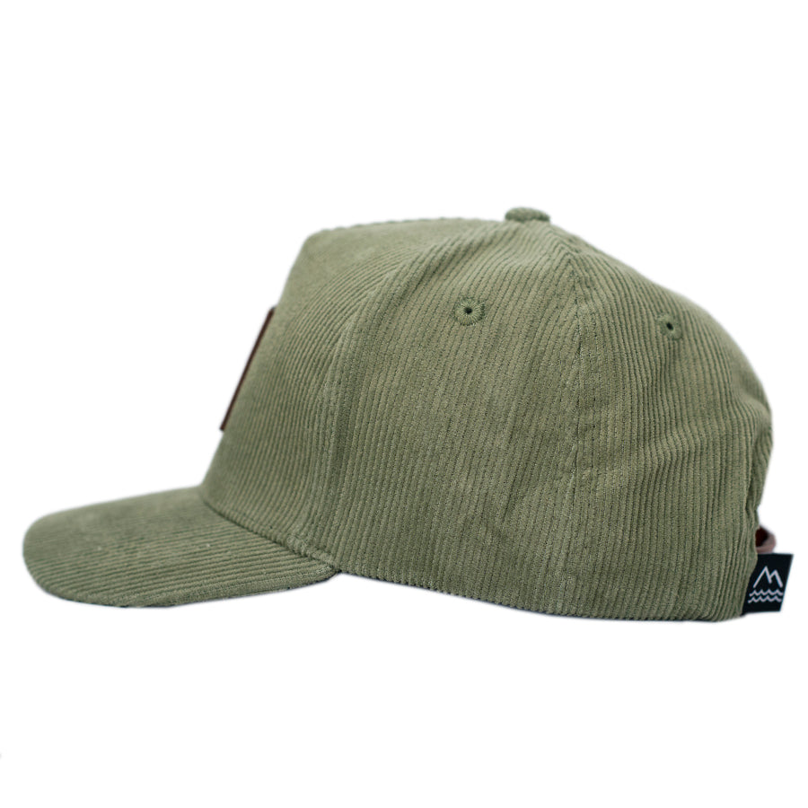 Green corduroy hat for toddlers and children with a brown leather patch.