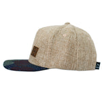 Load image into Gallery viewer, Tropical print children&#39;s hat with a linen crown and brown leather patch stamped with a compass design.
