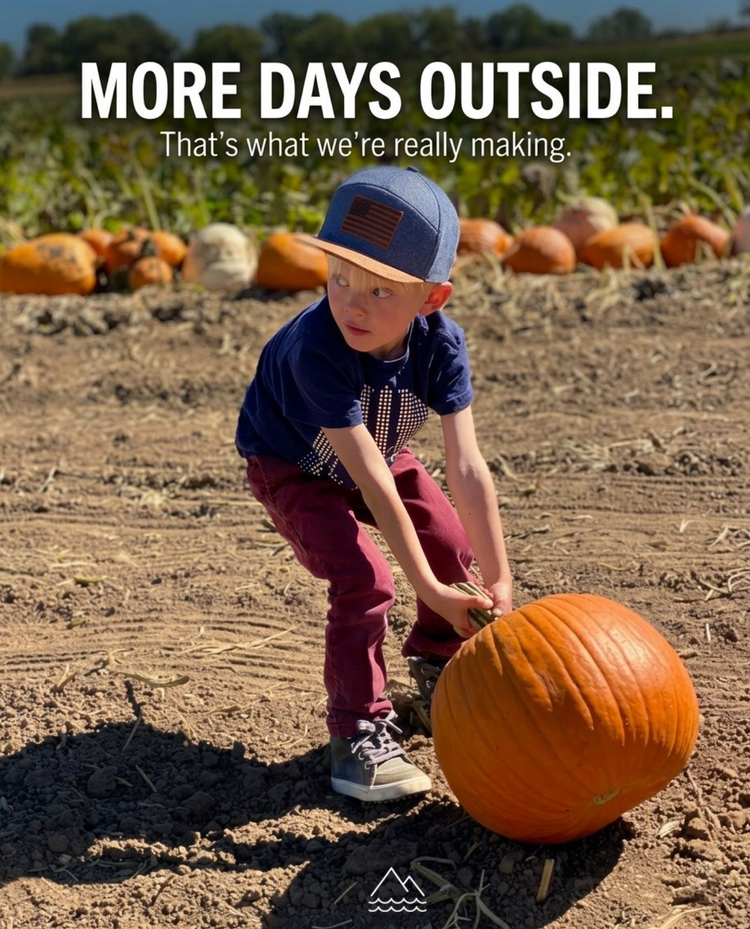Boy in a Wild &amp; Free snapback rolling a big pumpkin across a pumpkin patch, with the words More days outside