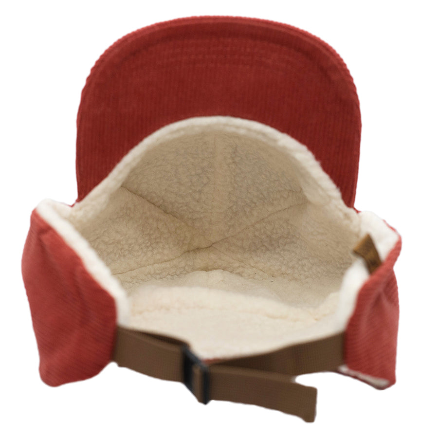 A cross between burnt orange and tomato red, our Zion Wooly children's flap hat is sure to keep your kids warm and stylish this winter. Our kid's winter trapper hats are fully lined with soft white fleece, warm corduroy outer shell, and a curved brim to keep the snow or winter sun off of their faces. Best yet, they have a pull cord on the back to customize your fit. Wear them clipped up or down, just be sure to get one for your winter adventures!